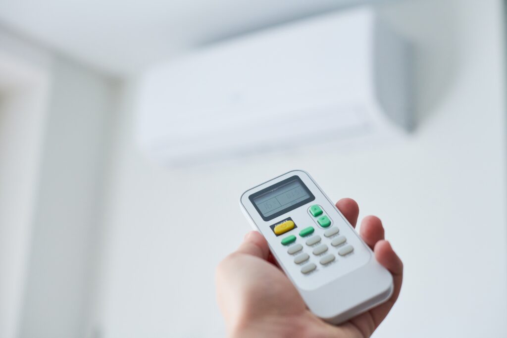 Air Conditioner - person pointing remote at air con